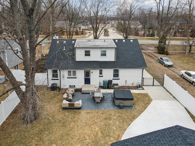 back of house with a lawn, roof with shingles, a fenced backyard, and a gate
