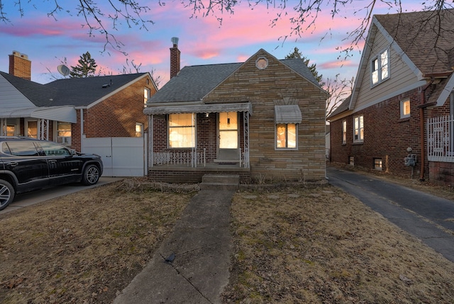 view of front of property with stone siding, brick siding, and a chimney