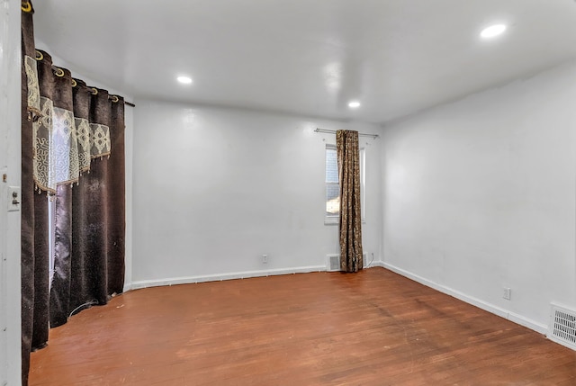 empty room with recessed lighting, visible vents, baseboards, and wood finished floors