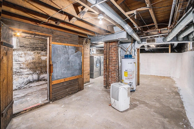 unfinished basement with gas water heater, visible vents, and separate washer and dryer