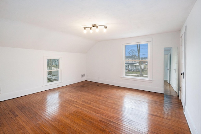 bonus room with lofted ceiling, wood-type flooring, visible vents, and baseboards