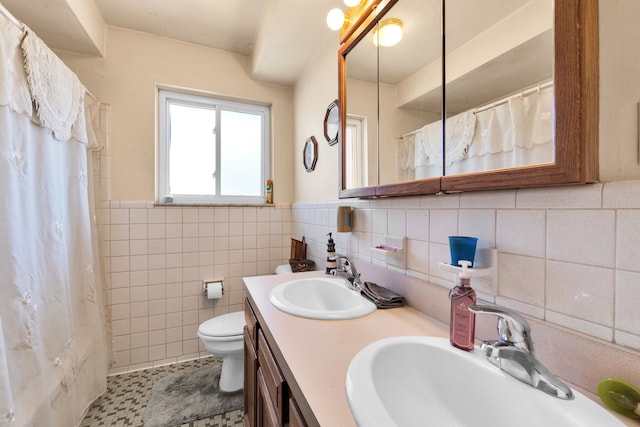 bathroom featuring toilet, a shower with curtain, tile walls, and a sink