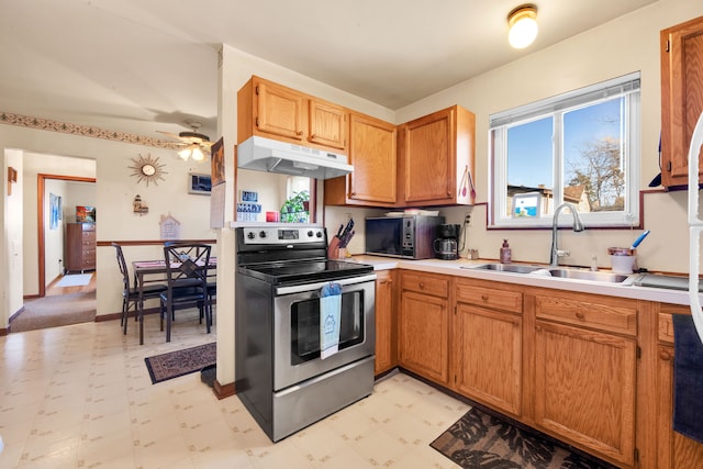 kitchen with under cabinet range hood, light floors, a sink, and stainless steel electric stove