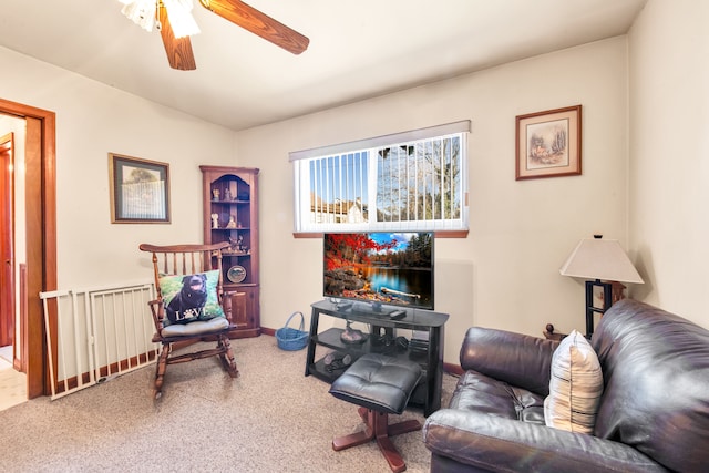 living area featuring carpet floors and a ceiling fan