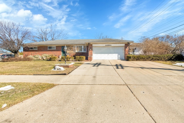 ranch-style house featuring a garage, brick siding, driveway, and a front lawn