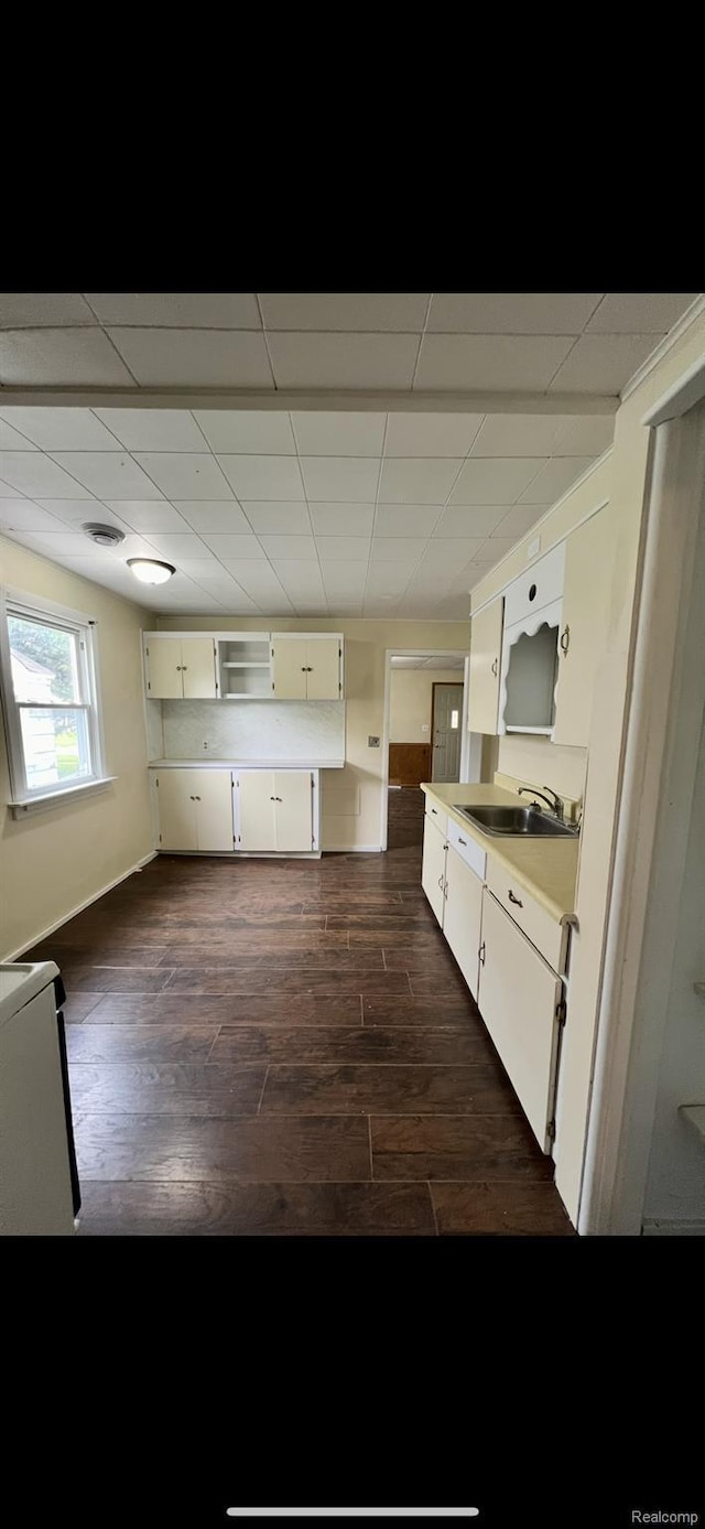 1531 Gilbert St, Saginaw, MI 48602 - kitchen featuring dark wood finished floors, light countertops, white cabinets, a sink, and a drop ceiling
