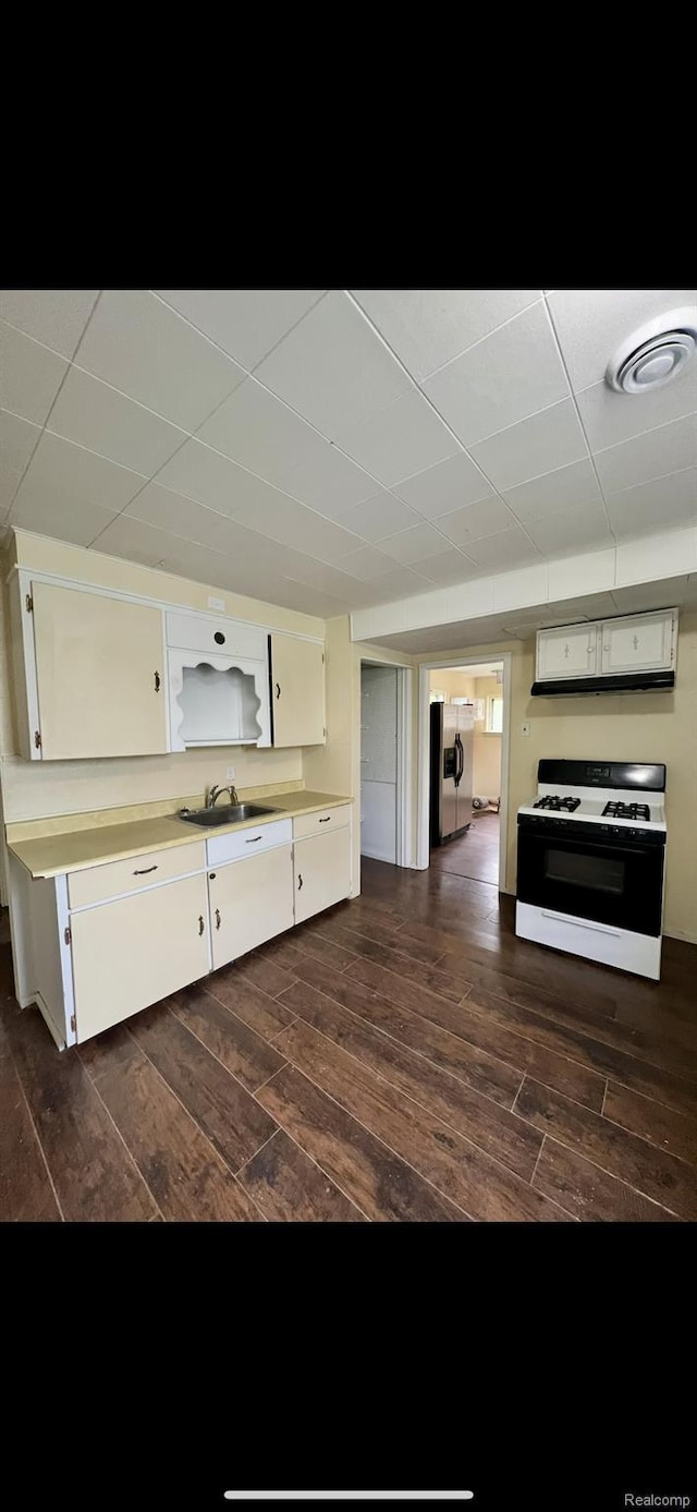 1531 Gilbert St, Saginaw, MI 48602 - kitchen featuring range with gas stovetop, a sink, white cabinetry, and dark wood-style flooring
