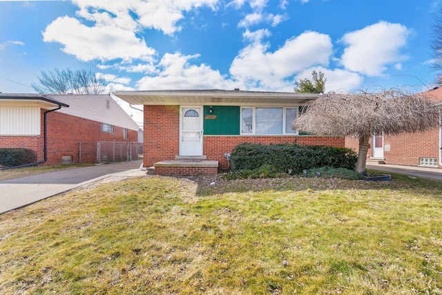 view of front of home with brick siding, fence, and a front lawn