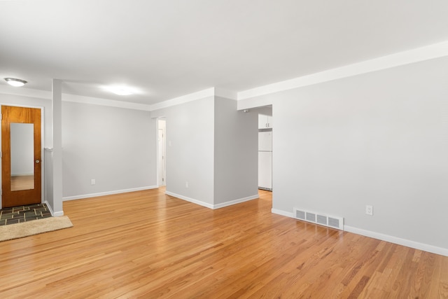 unfurnished room with light wood-type flooring, baseboards, and visible vents