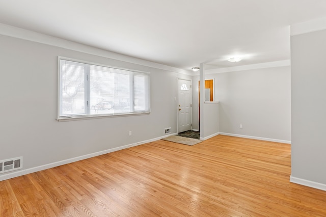 unfurnished room featuring light wood finished floors, baseboards, and visible vents