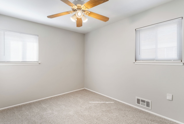 carpeted empty room with visible vents, ceiling fan, and baseboards