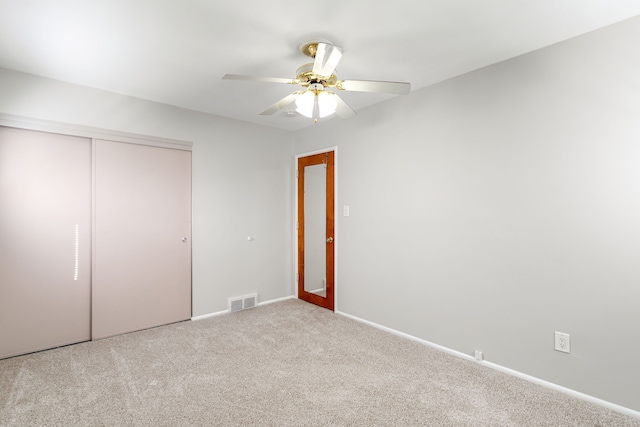 unfurnished bedroom featuring ceiling fan, carpet floors, visible vents, baseboards, and a closet