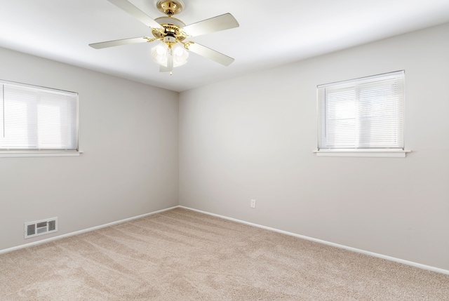 spare room featuring baseboards, carpet, visible vents, and a ceiling fan