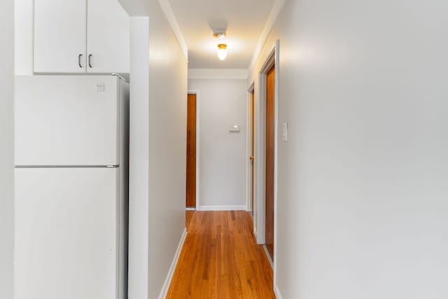 hall featuring light wood-style floors and baseboards