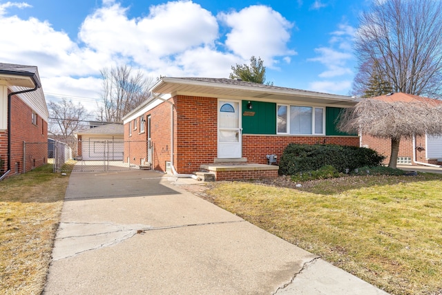 view of front of property with a garage, brick siding, a gate, fence, and a front yard