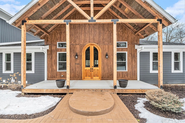 entrance to property with board and batten siding and a wooden deck