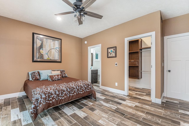 bedroom featuring wood tiled floor, ceiling fan, baseboards, and ensuite bathroom