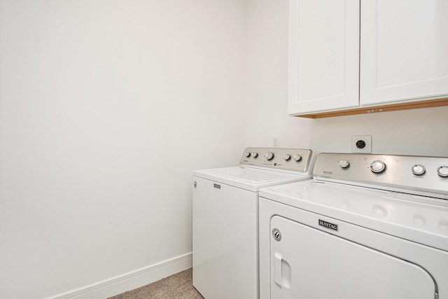 laundry room with washing machine and dryer, cabinet space, and baseboards