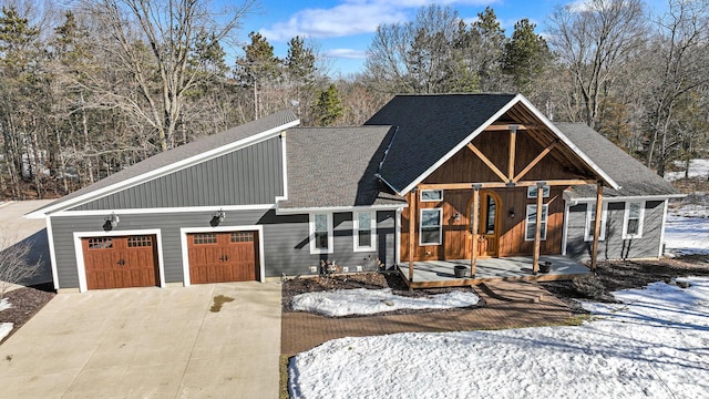 view of front of home featuring a garage, driveway, and roof with shingles