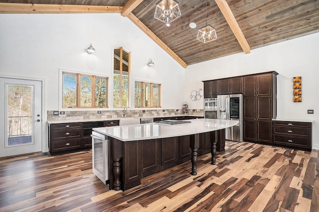 kitchen with high vaulted ceiling, light countertops, beamed ceiling, and light wood finished floors