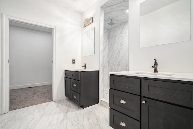 bathroom featuring a sink, marble finish floor, a shower, and two vanities