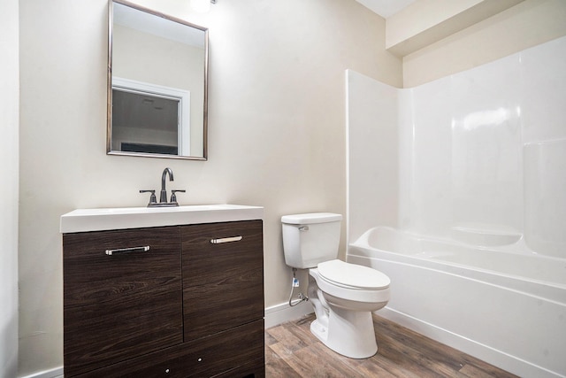 full bathroom featuring shower / bathtub combination, toilet, wood finished floors, vanity, and baseboards