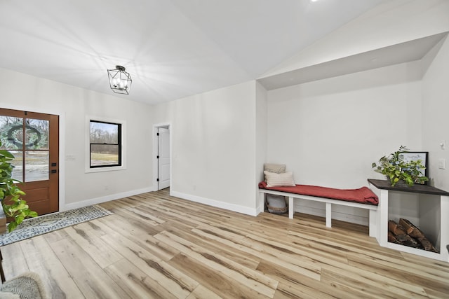 7450 Sears Rd, Horton, MI 49246 - foyer entrance with lofted ceiling, a notable chandelier, baseboards, and wood finished floors