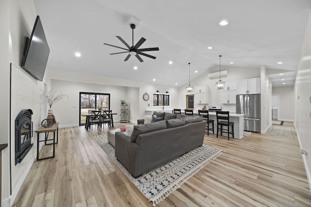 7450 Sears Rd, Horton, MI 49246 - living area featuring high vaulted ceiling, a fireplace, light wood-style flooring, and a ceiling fan