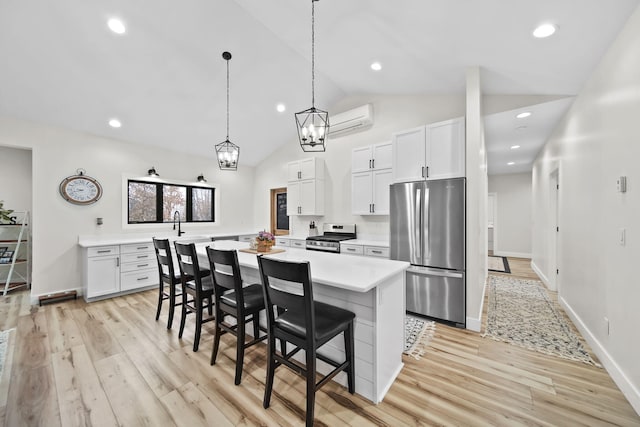 7450 Sears Rd, Horton, MI 49246 - kitchen featuring a center island, a breakfast bar, light countertops, appliances with stainless steel finishes, and a wall mounted air conditioner