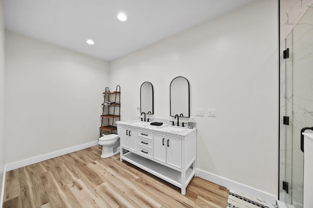 7450 Sears Rd, Horton, MI 49246 - bathroom with double vanity, a stall shower, baseboards, toilet, and wood finished floors