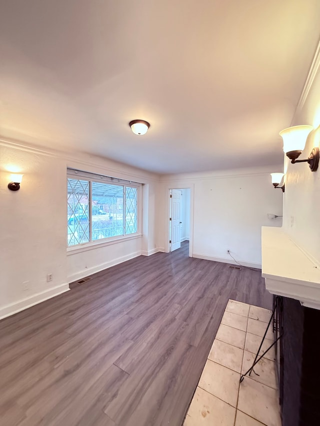 unfurnished living room featuring baseboards and wood finished floors