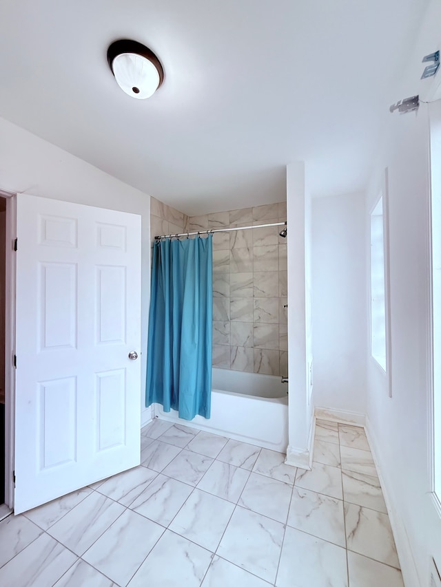 full bathroom with marble finish floor, shower / bathtub combination with curtain, and baseboards