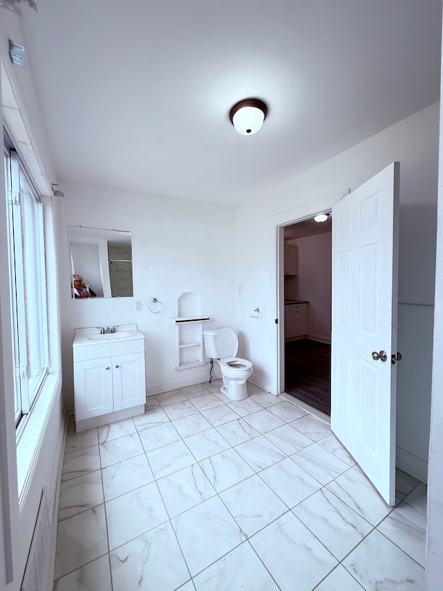 bathroom featuring toilet, visible vents, vanity, and baseboards