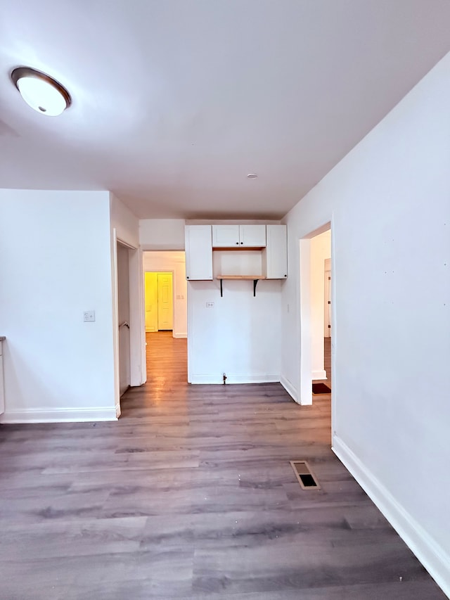 unfurnished living room with visible vents, baseboards, and wood finished floors