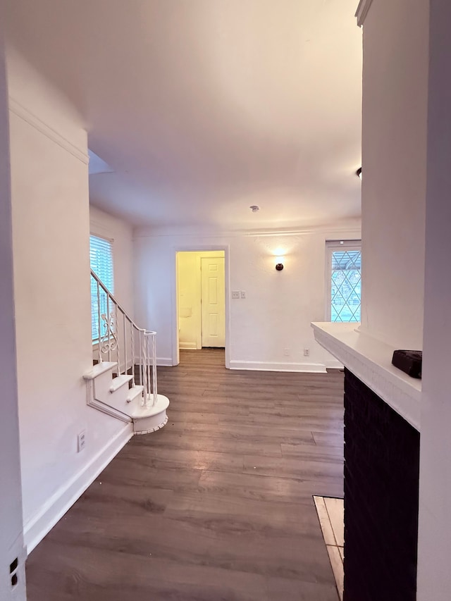 interior space with stairs, baseboards, and dark wood-type flooring