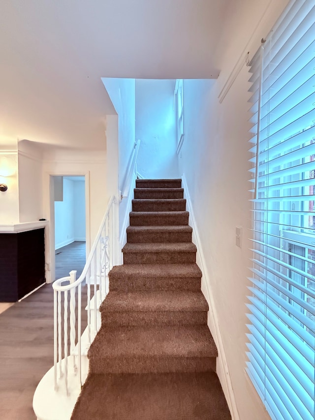 stairs featuring wood finished floors and baseboards