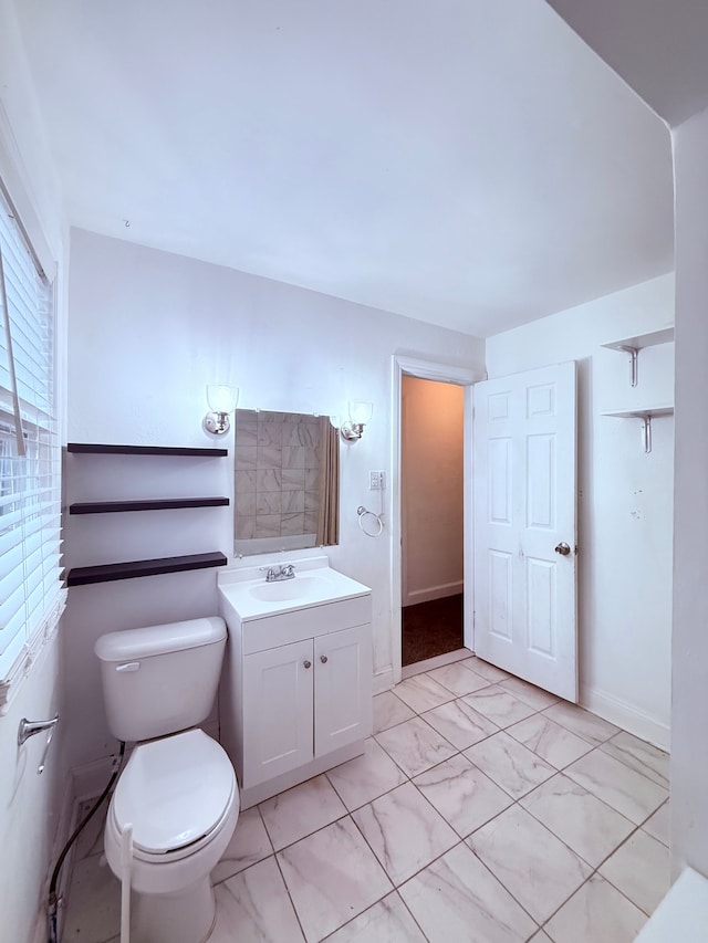 bathroom with marble finish floor, vanity, and toilet