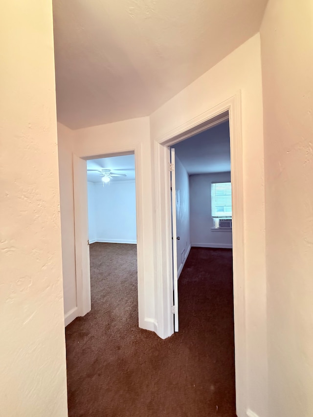 hallway with carpet floors and baseboards