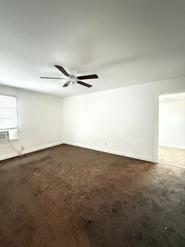 unfurnished room with dark carpet, a ceiling fan, and baseboards