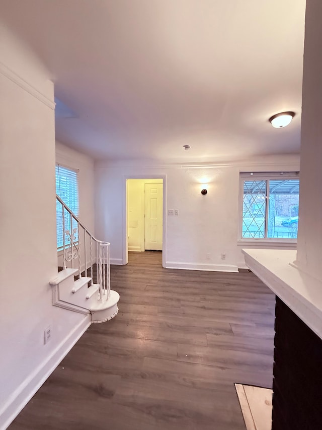 interior space featuring stairs, baseboards, and dark wood-style flooring