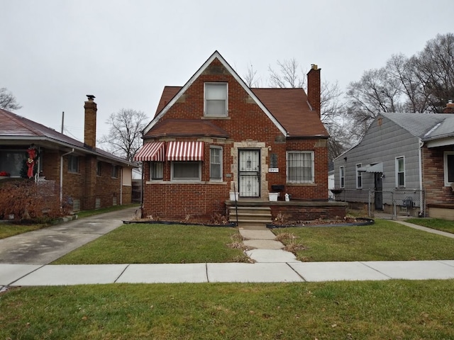 bungalow-style home featuring brick siding, a chimney, and a front lawn