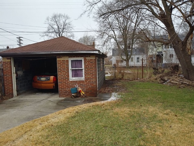 view of outbuilding with concrete driveway and fence