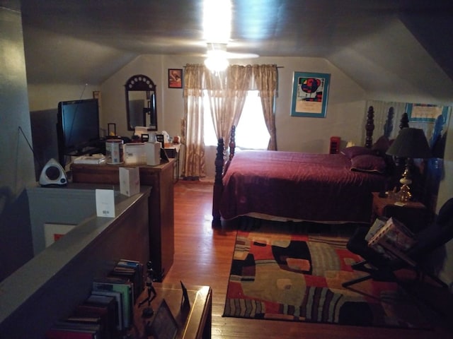 bedroom with lofted ceiling and wood finished floors