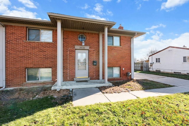 view of front of home featuring brick siding and a chimney