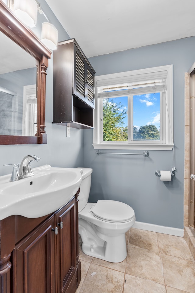 full bath featuring a shower with door, toilet, vanity, tile patterned flooring, and baseboards