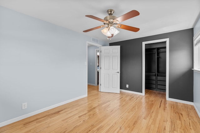 unfurnished bedroom with visible vents, baseboards, a spacious closet, a closet, and light wood finished floors