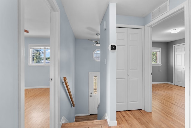 foyer entrance featuring light wood-type flooring, baseboards, visible vents, and ceiling fan