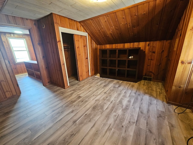 bonus room with wooden ceiling, wood finished floors, and wood walls