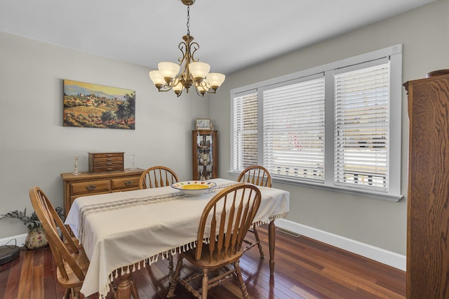 dining space with baseboards, a chandelier, and dark wood-type flooring