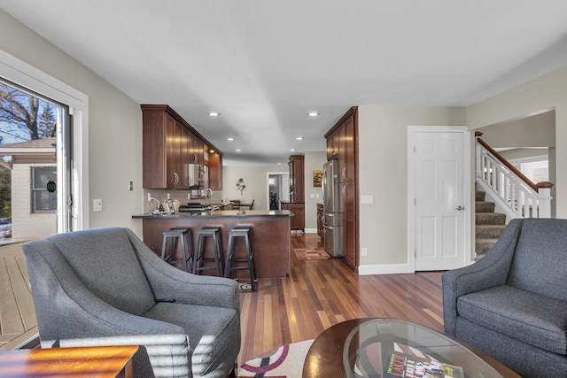 living room featuring dark wood-type flooring, a wealth of natural light, stairway, and recessed lighting